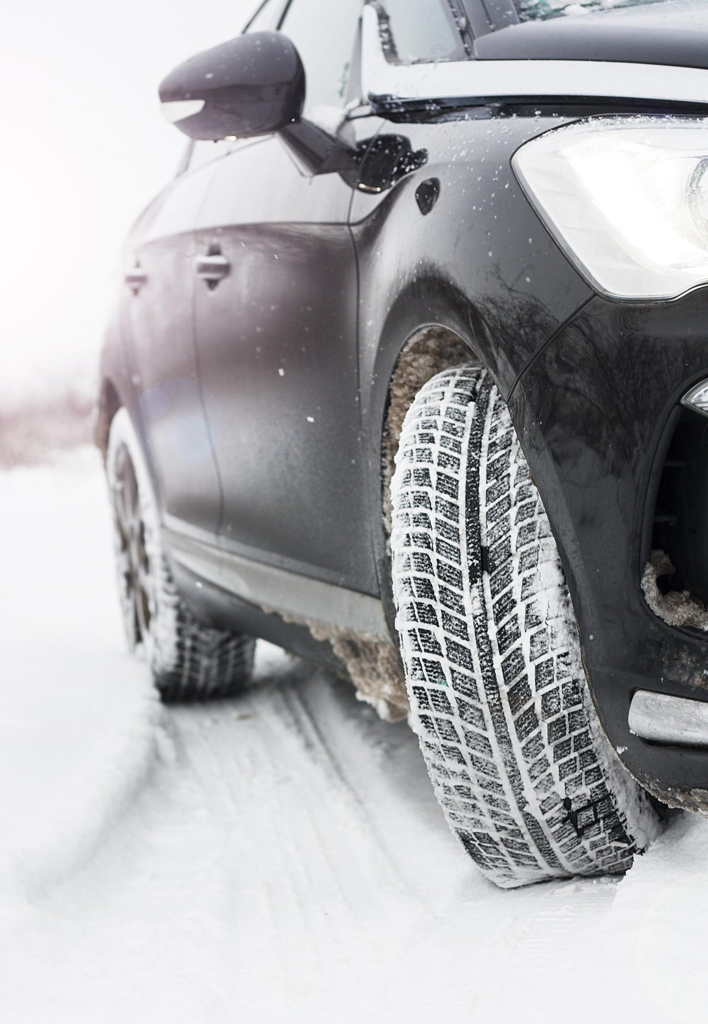 Auto mit Winterreifen auf verschneiter Strasse